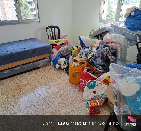 חדר עם ערימות בגדים, צעצועים ושקיות פלסטיק
